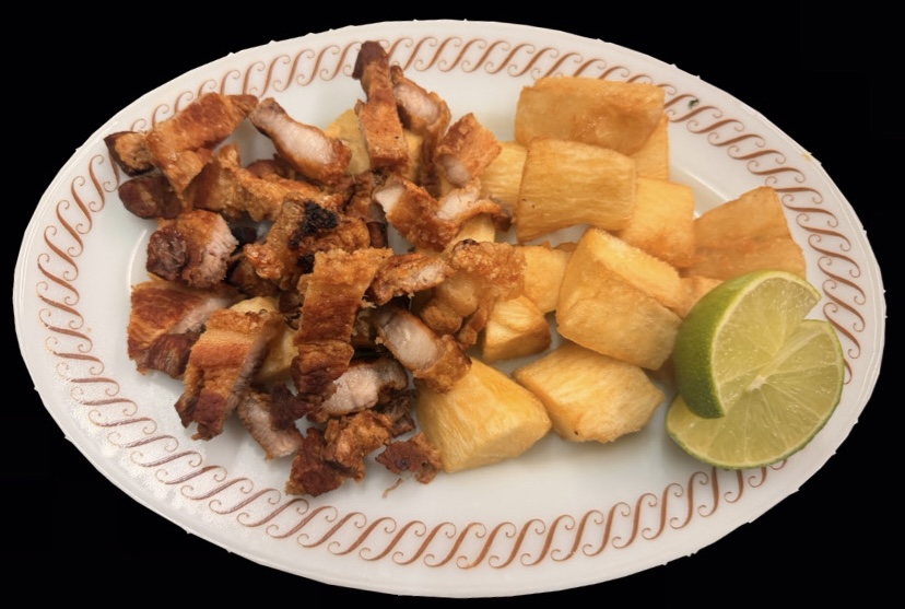 Chicharrón crujiente con yuca frita y limón